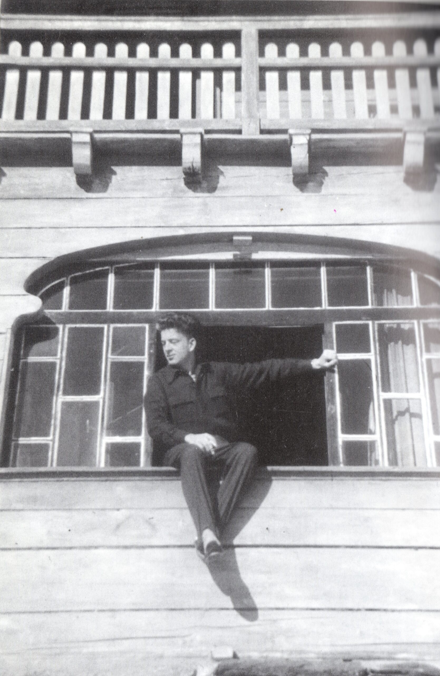 Hans Lodeizen sits on a windowsill, his legs dangling against the exterior wall.
