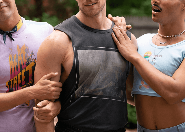 From left to right: Matt Rogers, Zane Phillips and Tomás Matos in the film Fire Island. Rogers and Matos are draping their hands affectionately on Phillips.